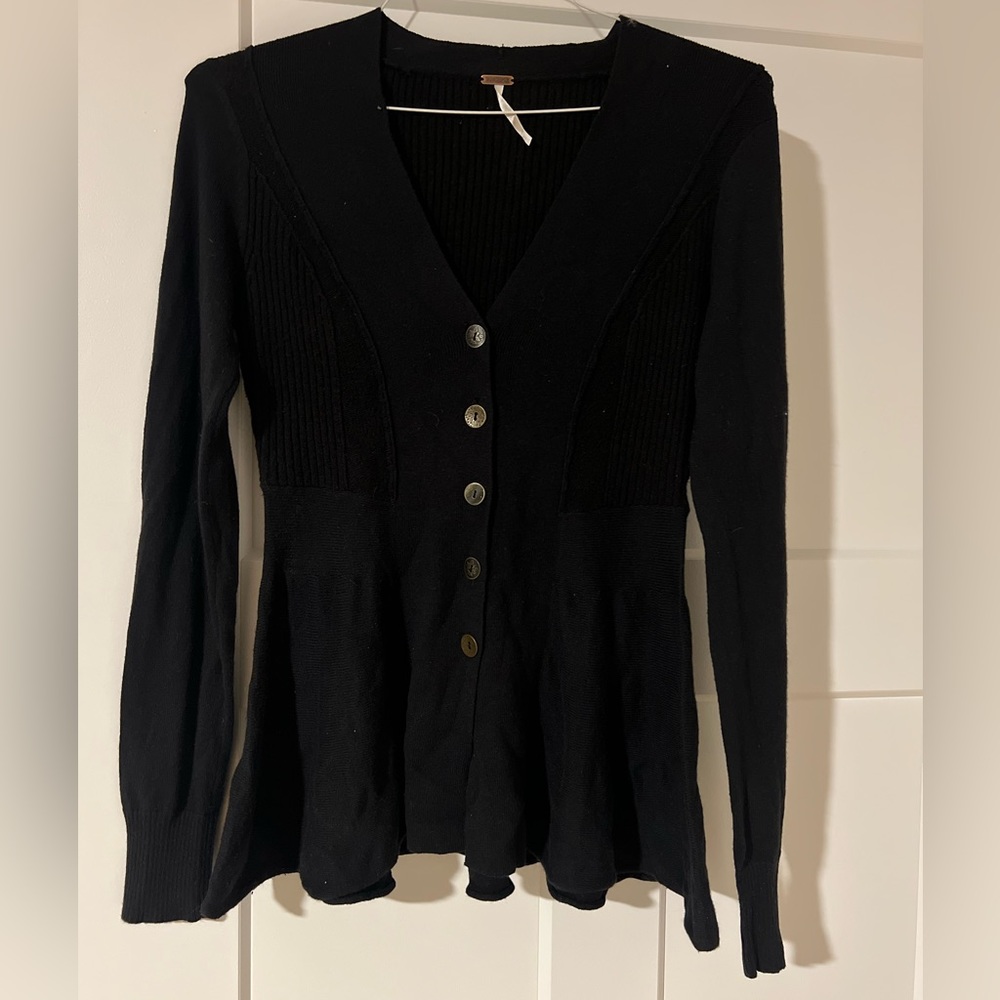 A navy free people sweater - flares out a the bottom